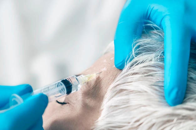 Iniezioni di Botox Donna anziana che riceve l'iniezione di Botox