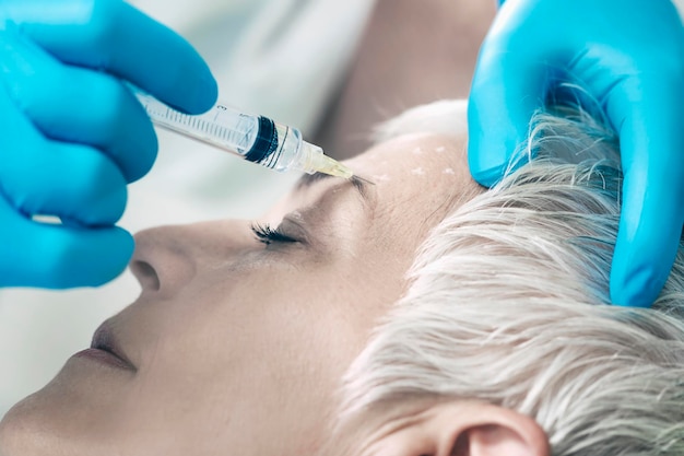 Iniezioni di Botox Donna anziana che riceve l'iniezione di Botox