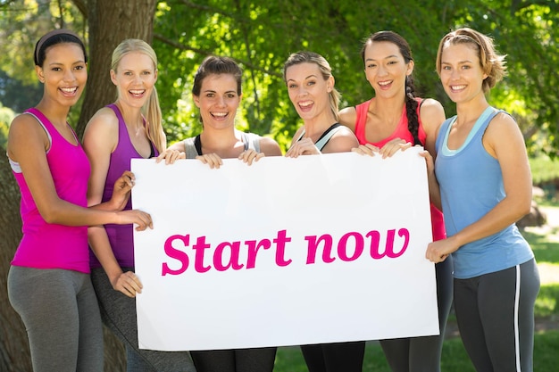 Inizia ora contro il gruppo di fitness che tiene il poster nel parco