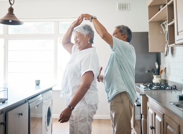 Inquadratura di una coppia senior che balla in cucina a casa