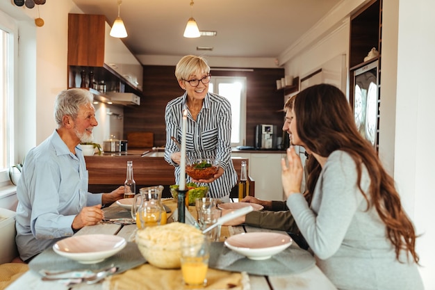 Inquadratura di una famiglia che mangia insieme al chiuso