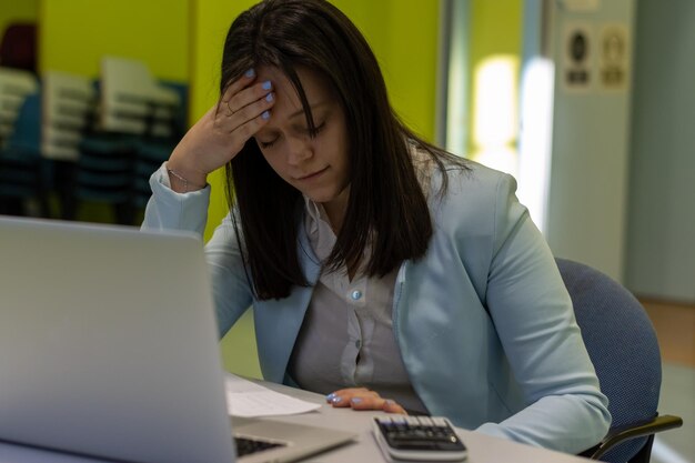 Inquadratura di una giovane donna d'affari che sembra stressata mentre lavora in un ufficio Quando la strada per il successo porta allo stress Donna che soffre di stress mentre usa un computer alla sua scrivania