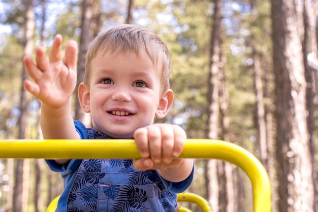 Inquadratura poco profonda di un bambino sorridente che si diverte nel parco giochi