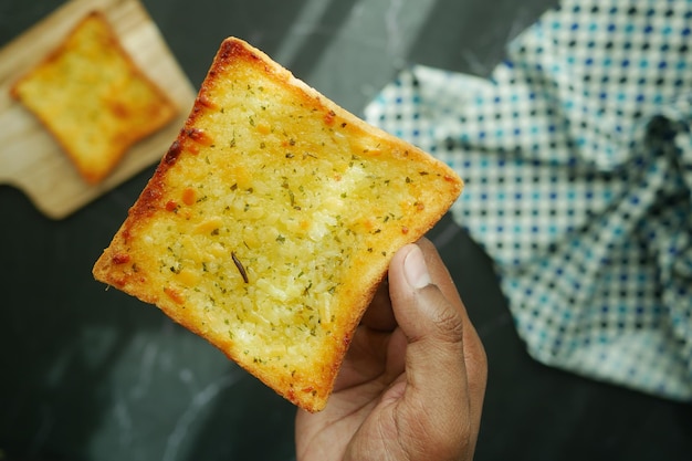 Inquadratura POV di tenere un pane all'aglio