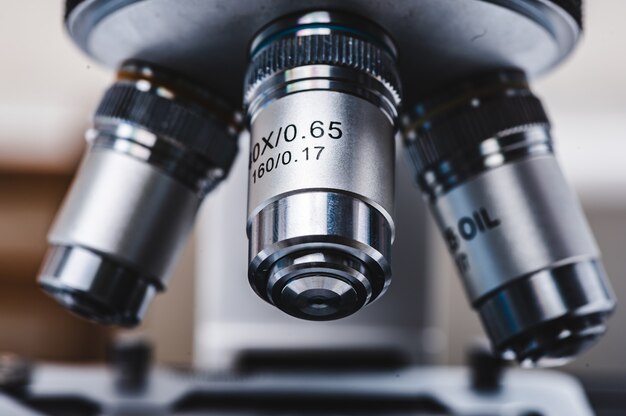 Inquadratura ravvicinata del microscopio scientifico professionale con impostazione di lenti in metallo presso il laboratorio medico