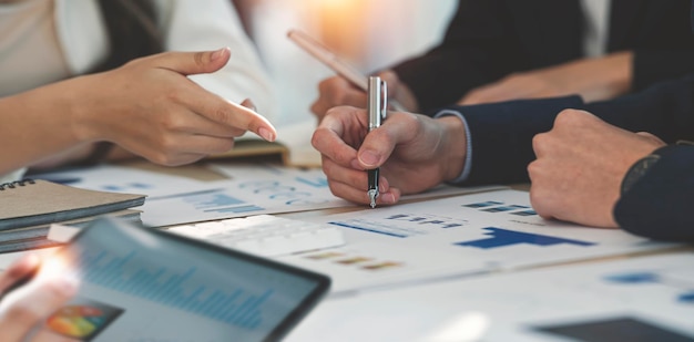 Inquadratura ritagliata di diversi colleghi che lavorano insieme nella sala del consiglio discutendo e analizzando la strategia aziendale