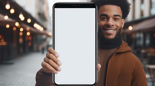 Inquadratura una ripresa di un uomo allegro ed emotivo che tiene in mano un grande cellulare vuoto che mostra uno schermo bianco e ti indica