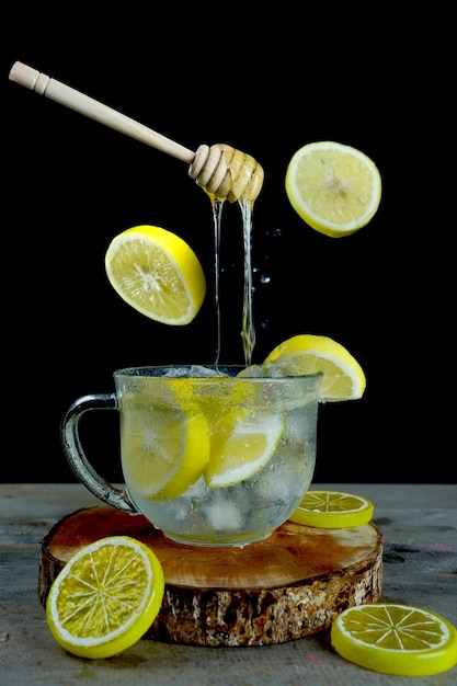Inquadratura verticale del mestolo di miele galleggiante su una limonata ghiacciata, perfetto per il menu delle bevande