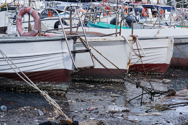 Inquinamento ambientale - detriti sulla superficie dell'acqua tra le navi ormeggiate nel porto