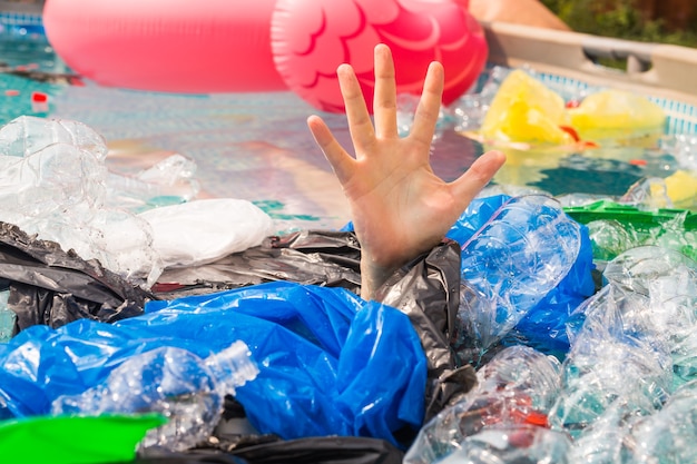 Inquinamento plastico e problema ambientale, mano d'uomo nel mare di plastica