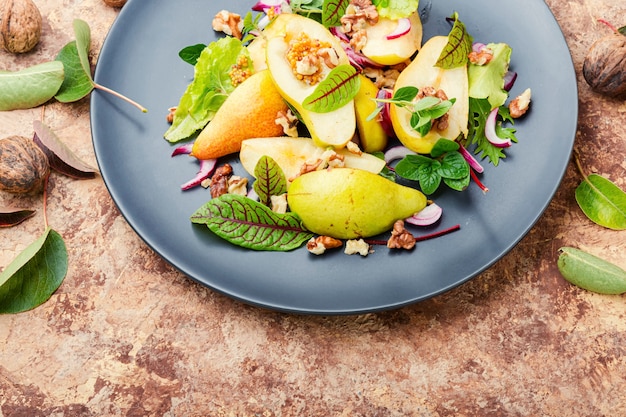 Insalata appetitosa con pera ed erbe aromatiche.Insalata salutare a base di foglie verdi e pere