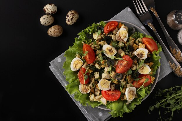 Insalata biologica con pollo pomodorini uova di quaglia olive nere e microgreens