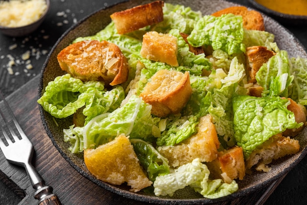 Insalata Caesar classica con crostini fatti in casa croccanti al parmigiano e salsa Caesar in un piatto