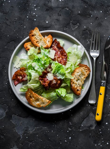 Insalata Caesar con pancetta su sfondo scuro Vista dall'alto Deliziose tapas per antipasti per brunch