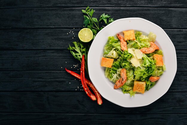 Insalata Caesar con pollo e verdure fresche su uno sfondo di legno Vista dall'alto Spazio di copia