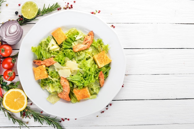 Insalata Caesar con pollo e verdure fresche su uno sfondo di legno Vista dall'alto Spazio di copia