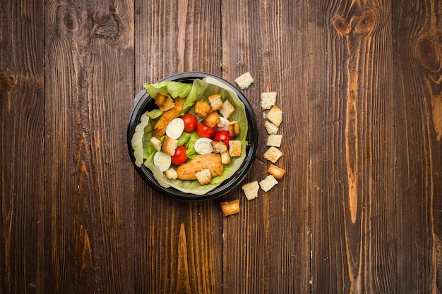 Insalata Caesar con pollo pomodorini e uova di quaglia su un piatto