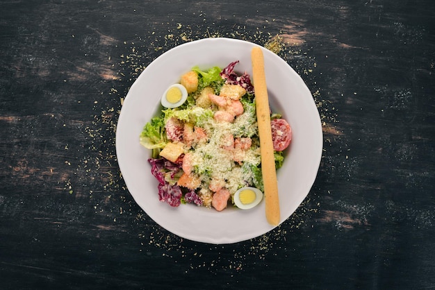 Insalata Caesar con salmone Verdure fresche Cibo sano Vista dall'alto Su uno sfondo di legno bianco Copia spazio