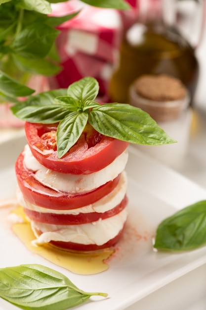 Insalata caprese con mozzarella italiana su piatto bianco