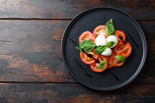 Insalata caprese con pomodori a fette, mozzarella, basilico, olio d'oliva