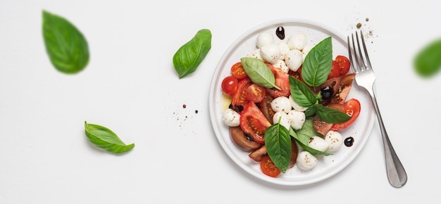 Insalata caprese con pomodoro basilico mozzarella salsa balsamica e olio d'oliva