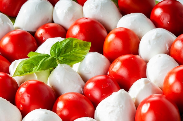 Insalata caprese del primo piano. Insalata mediterranea. Mozzarella Pomodorini Basilico Cucina Italiana.