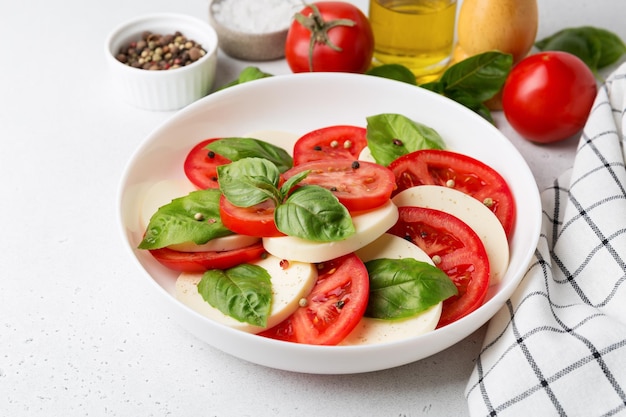 Insalata caprese di pomodoro fresco a fette, mozzarella e basilico