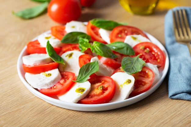 Insalata caprese. Famosa insalata italiana con pomodori freschi, mozzarella e basilico, immagine ravvicinata