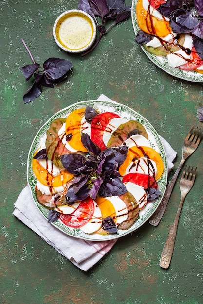 Insalata caprese Fette di pomodoro e mozzarella con foglie di basilico