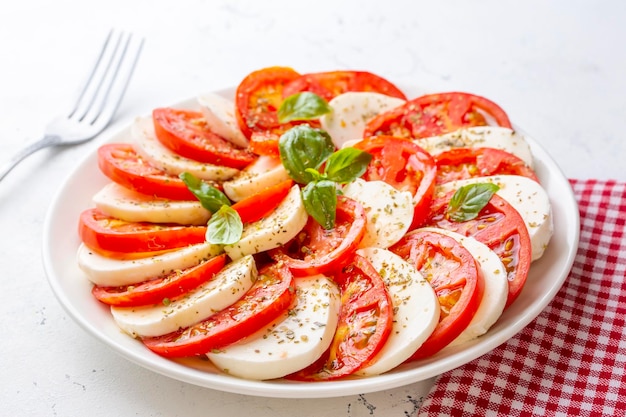 Insalata caprese italiana con pomodori a fette, mozzarella, basilico, olio d'oliva