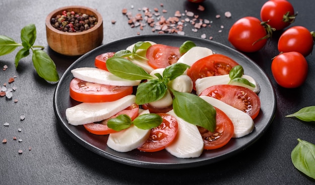 Insalata caprese italiana con pomodori a fette, mozzarella, basilico, olio d'oliva