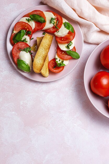 Insalata caprese italiana fatta in casa con pomodori a fette, mozzarella, basilico