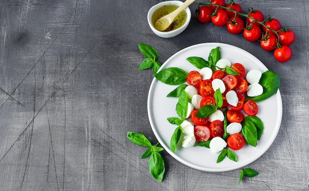 Insalata caprese italiana: pomodori rossi, mozzarella e basilico, cucina italiana. Pranzo sano