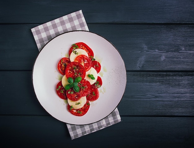 Insalata caprese Piatto tradizionale italiano pomodori con mozzarella basilico e spezie vista dall'alto senza persone