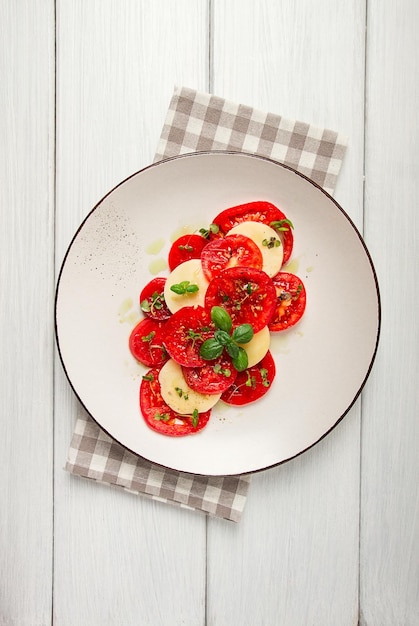 Insalata caprese Piatto tradizionale italiano pomodori con mozzarella basilico e spezie vista dall'alto senza persone