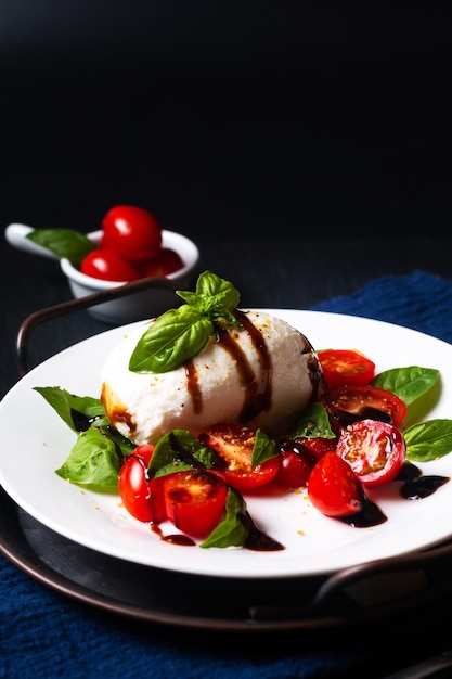 Insalata caprese rustica di concetto di cibo sano su sfondo nero con spazio di copia