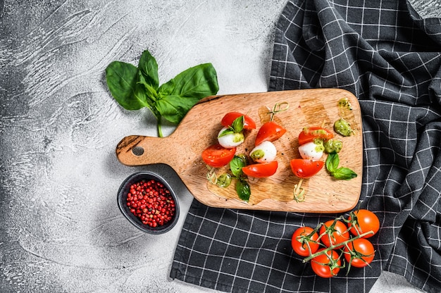 Insalata caprese su spiedino, pomodoro, pesto e mozzarella. Spuntino di tartine