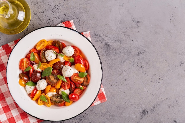 Insalata caprese tradizionale fatta di pomodori freschi a fette, mozzarella e basilico, vista dall'alto