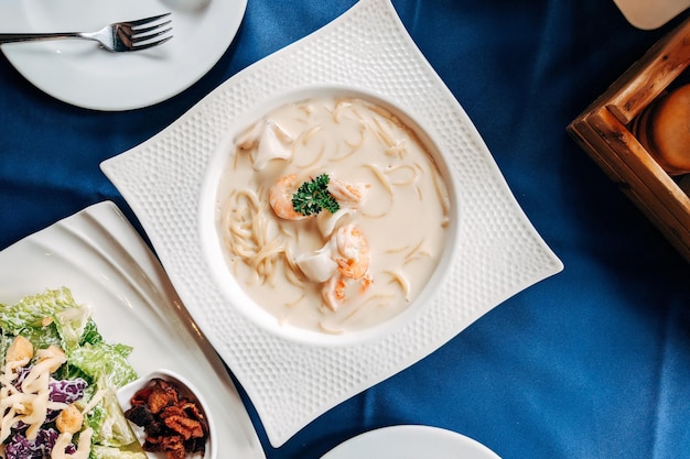 Insalata cesar e spaghetti ai frutti di mare piatti Vista dall'alto tavolo del cibo italiano