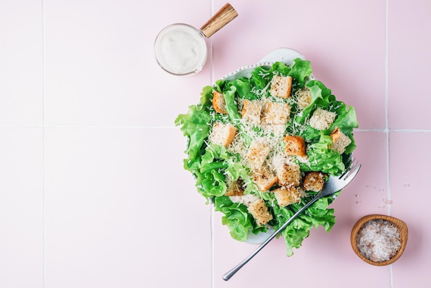 Insalata cesare tradizionale con lattuga, grano, crouton, parmigiano e salsa