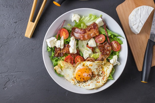 Insalata chetogenica Uovo fritto con pancetta pomodori formaggio blu e lattuga Ricetta per l'insalata cheto perfetta Vista dall'alto