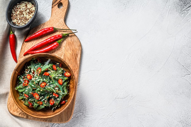 Insalata con alghe wakame e peperoncino rosso. Sfondo grigio. Vista dall'alto. Copia spazio