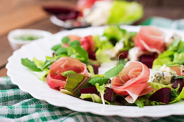 Insalata con barbabietola al forno, gorgonzola, prosciutto e mix verde con pesto.