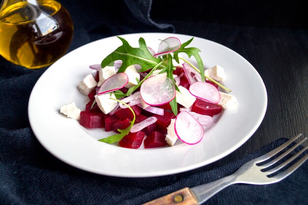 Insalata con barbabietole e ravanelli su sfondo nero