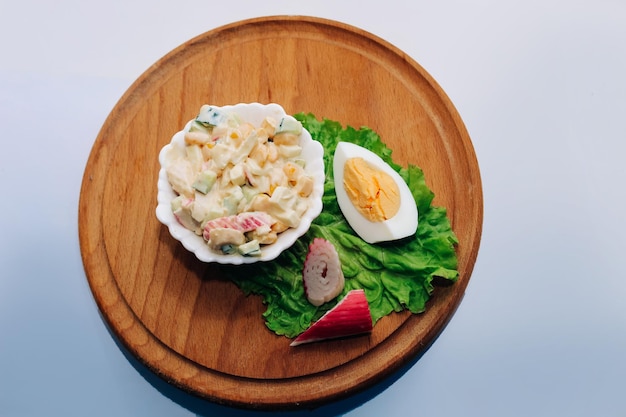 Insalata con bastoncini di granchio, mais e uova di cetriolo a cubetti con maionese su una tavola