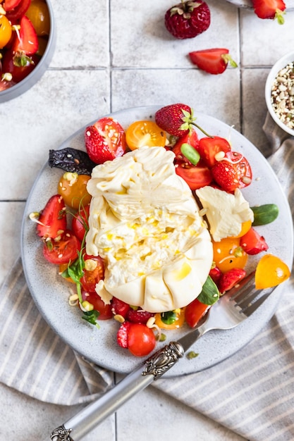 Insalata con burrata pomodorini e fragole con micro dieta Keto olio verde e olio d'oliva