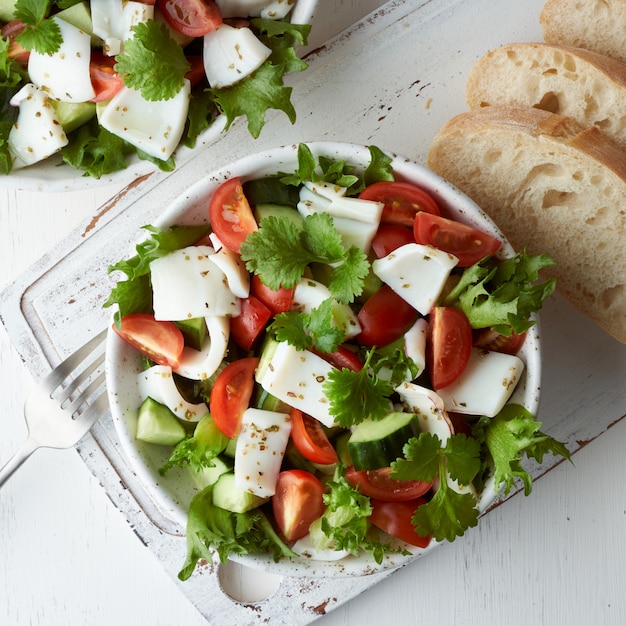 Insalata con calamari, cetrioli, pomodori e lattuga.