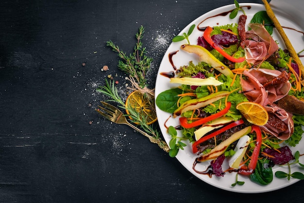 Insalata con carne e foglie di insalata Su una superficie di legno Vista dall'alto Spazio libero per il testo