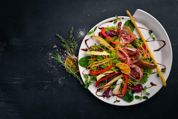 Insalata con carne e foglie di insalata Su una superficie di legno Vista dall'alto Spazio libero per il testo