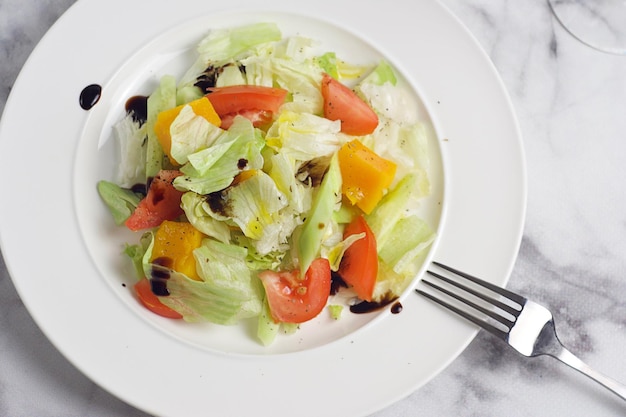 Insalata con cavolo cappuccio pomodori cetriolo zucca in un piatto sul tavolo di marmo Colazione